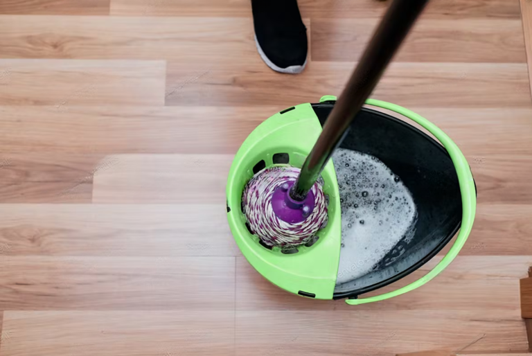 cleaning wooden floors with mop and bucket in a bright living room